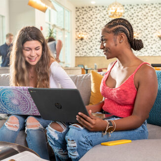 Young young woman having a conversation while using their laptop computers